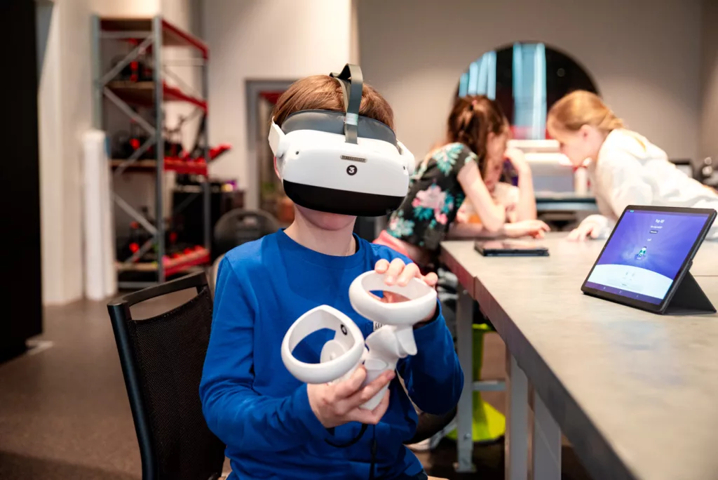 Bērns iepazīst virtuālās realitātes tehnoloģijas izzinošā nodarbībā